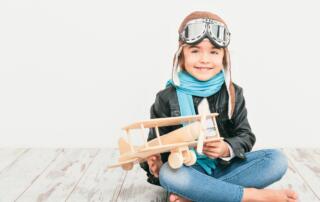 little girl with airplane toy and googles