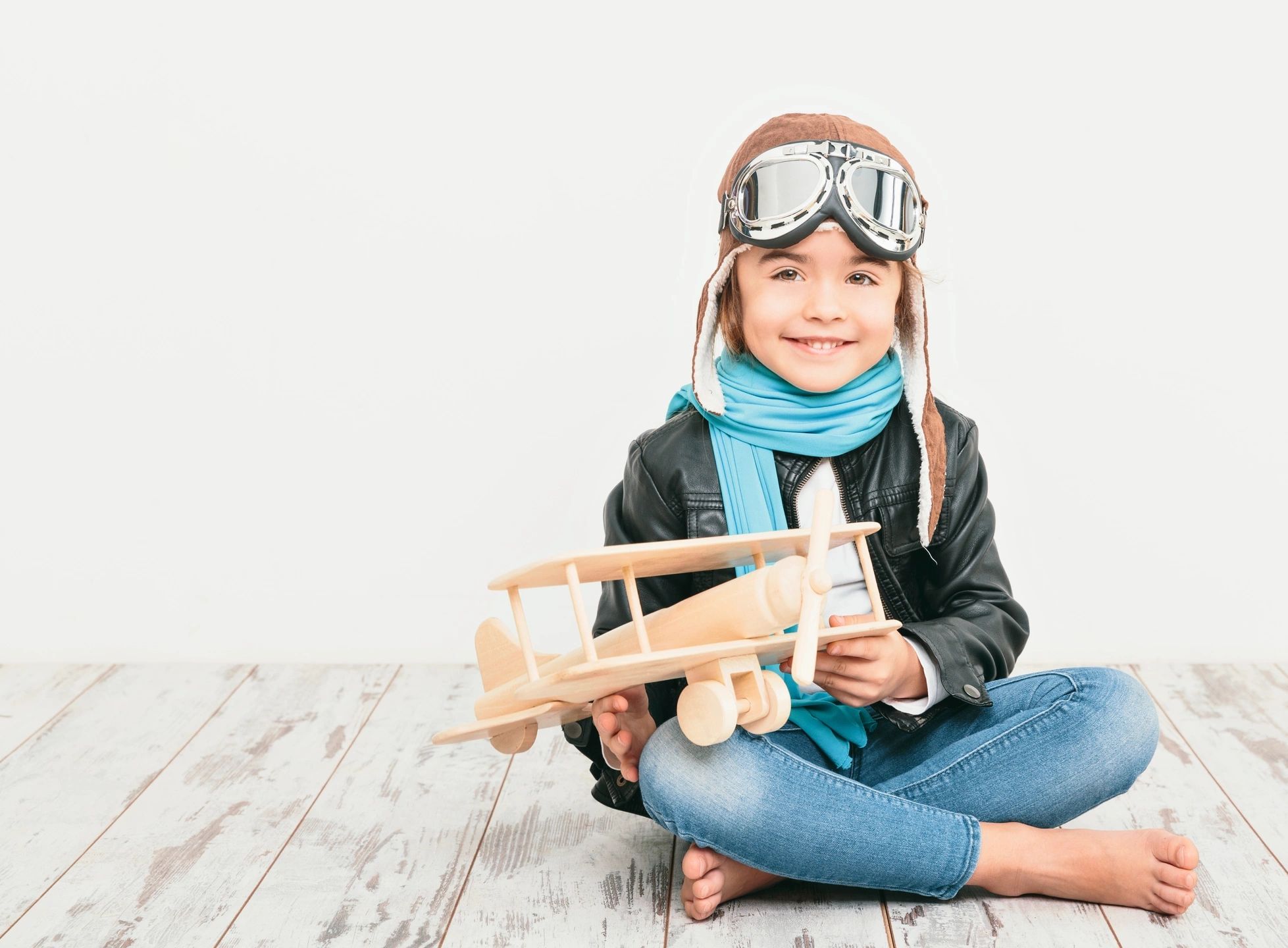 little girl with airplane toy and googles