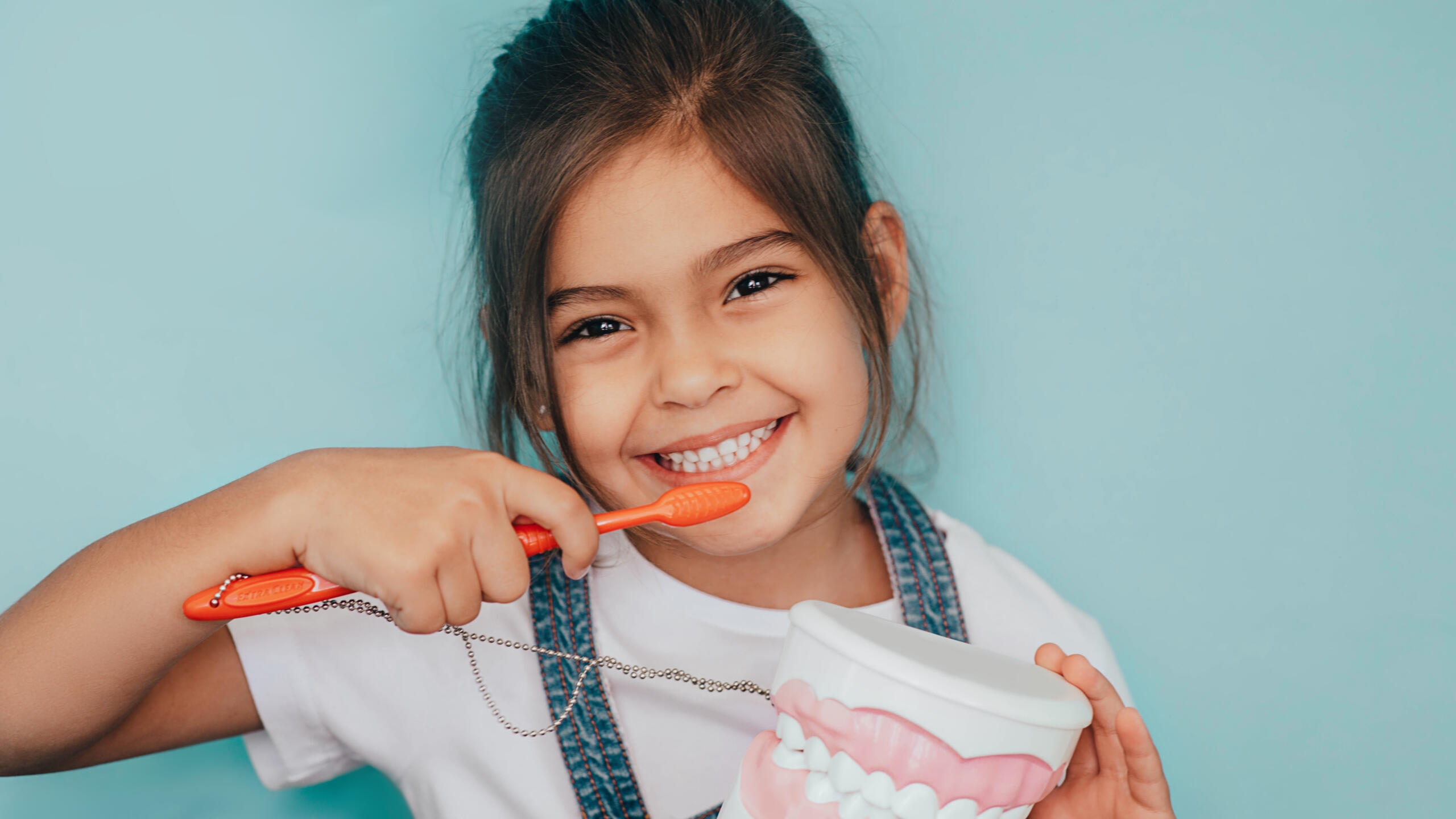 little girl smiling after brushing her teeth from floss boss